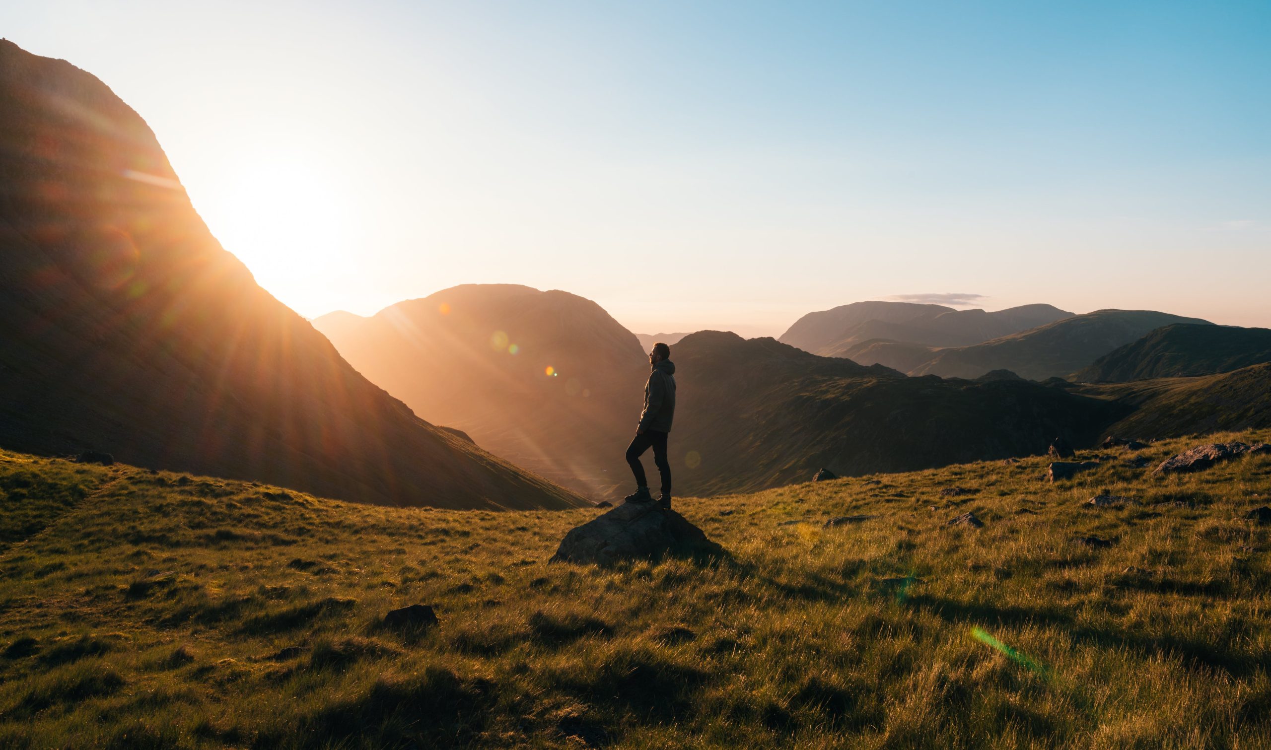 Imagen de un hombre en la naturaleza viendo el amanecer